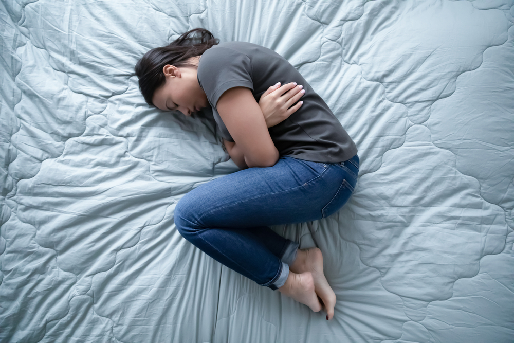 Woman lying on her bed in an article on eating disorders and depression by Greta Gleissner is the Founder of Eating Disorder Recovery Specialists