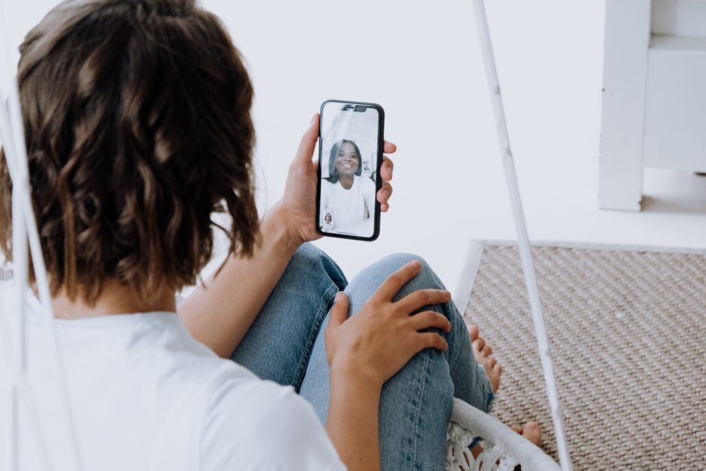 woman looking at her phone while on a video call