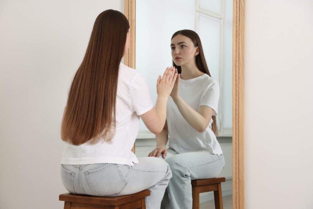 dysmorphia dysmorphia as girl looks in a mirror at her body
