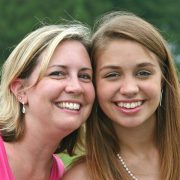 Mother side by side smiling with daughter